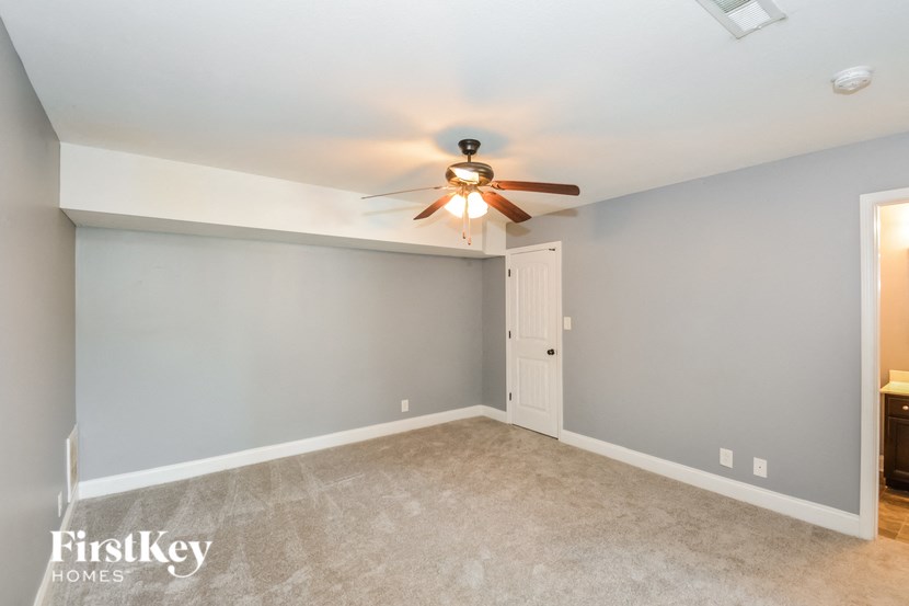 A room with a ceiling fan and a door.