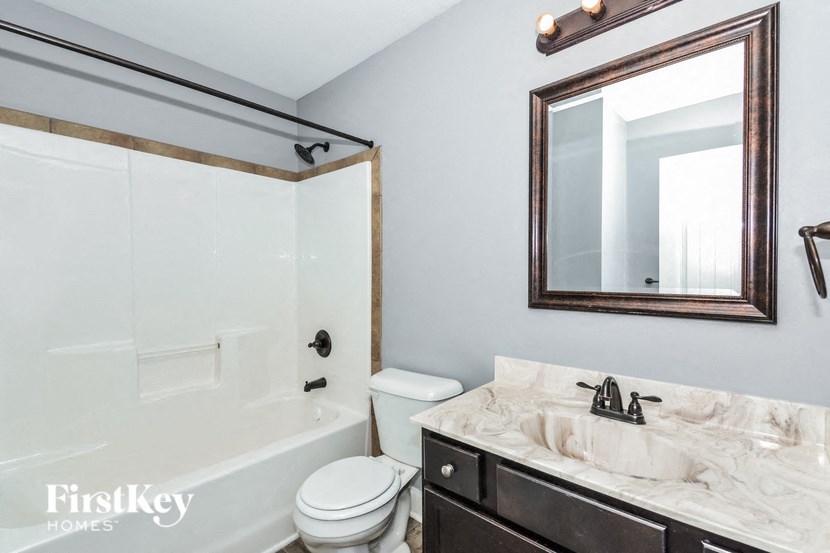 A bathroom with a marble countertop and a white toilet.