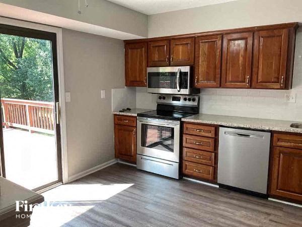 A kitchen with wooden cabinets and stainless steel appliances.