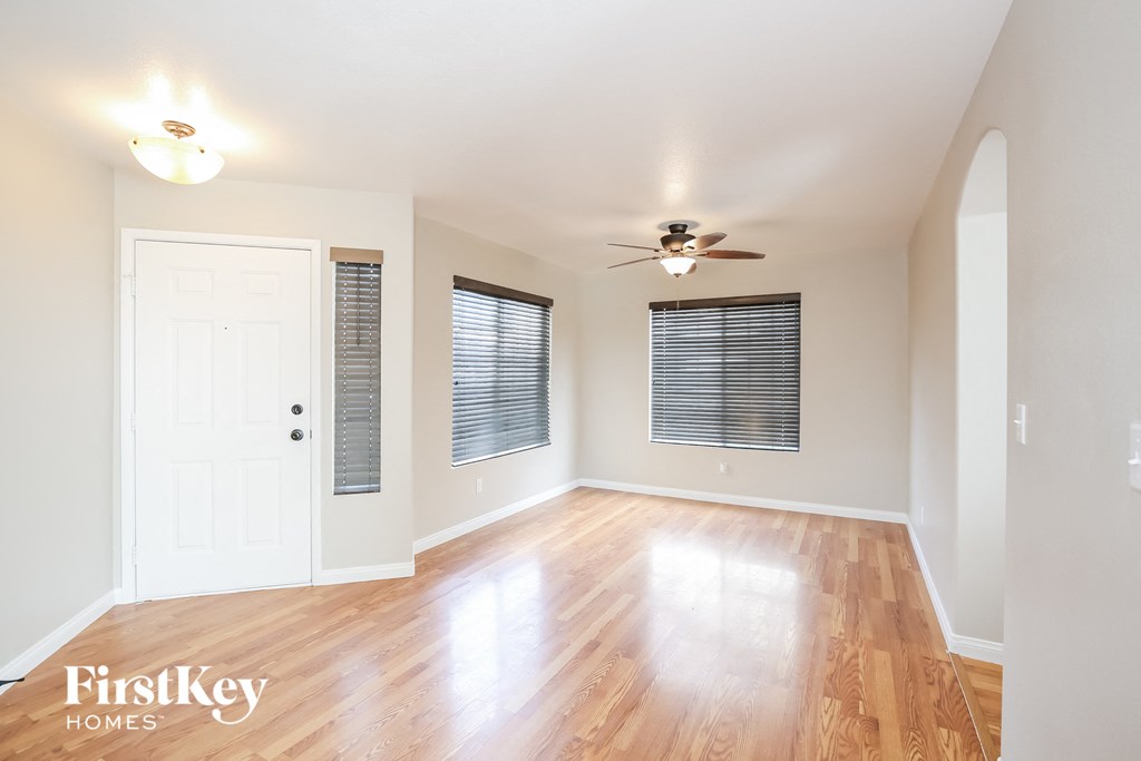 A room with wooden floors and a ceiling fan.