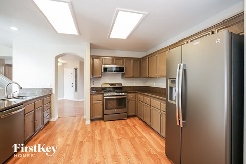 A kitchen with wooden floors and a refrigerator.