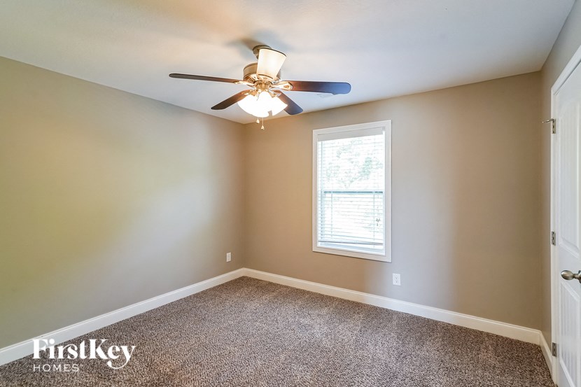 a bedroom with a ceiling fan and a window