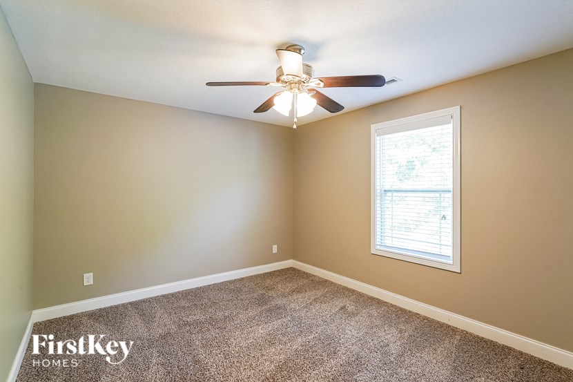 a bedroom with a ceiling fan and a window