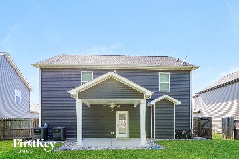 the front of a blue house with a yard and grass