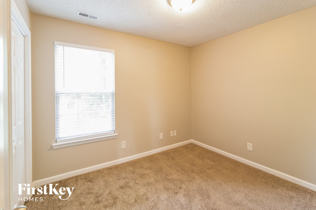a bedroom with carpet and a window