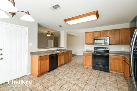 A kitchen with wooden cabinets and black appliances.