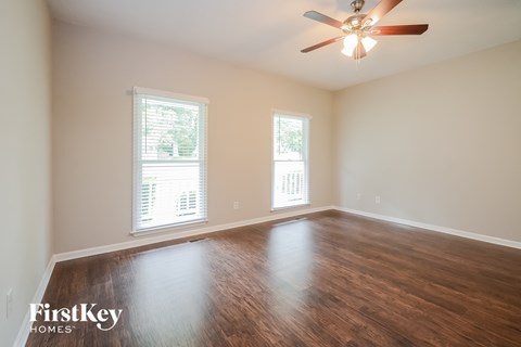A room with wooden floors and a ceiling fan.