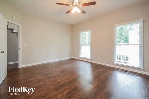 A room with a wooden floor and a ceiling fan.