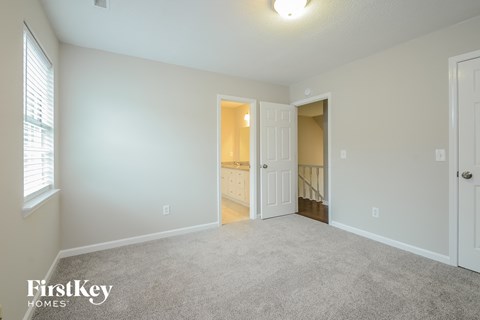 A spacious room with a carpeted floor and white walls.