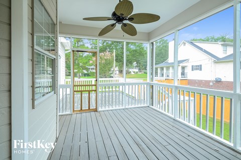A balcony with a ceiling fan and a view of the backyard.