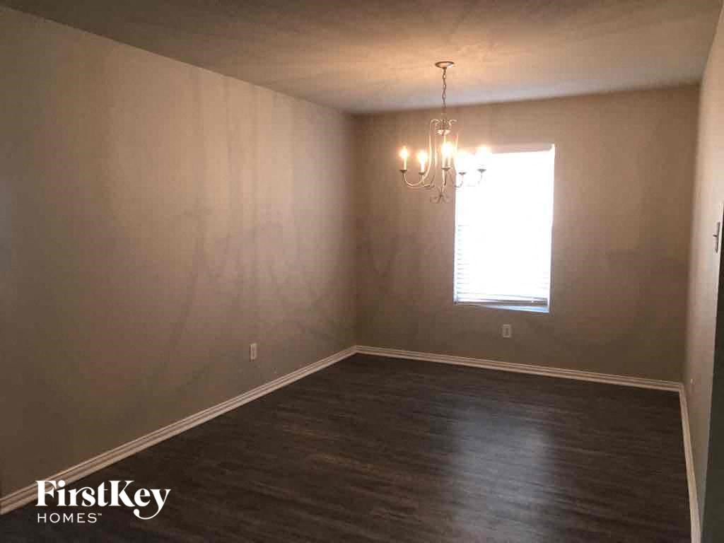 a empty living room with wood floors and a window
