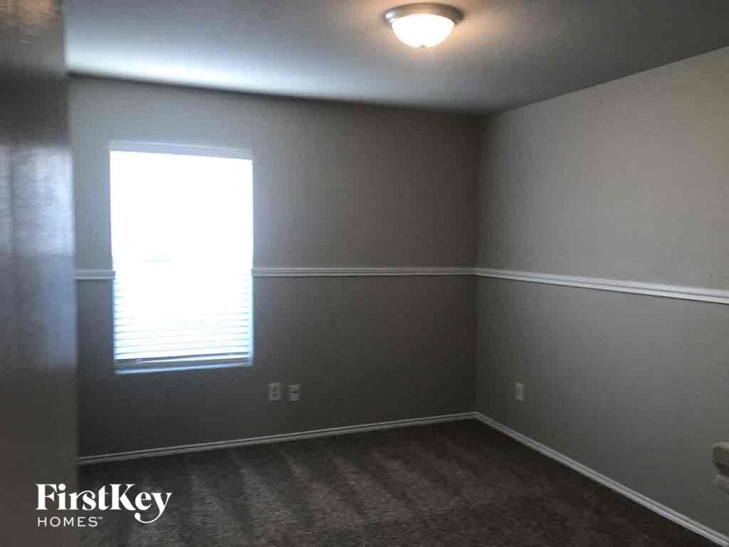 an empty room with gray walls and a window