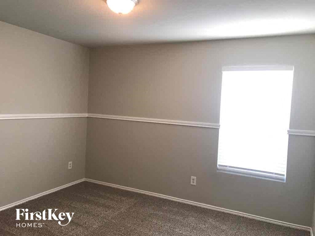 a room with gray walls and a window and a carpet