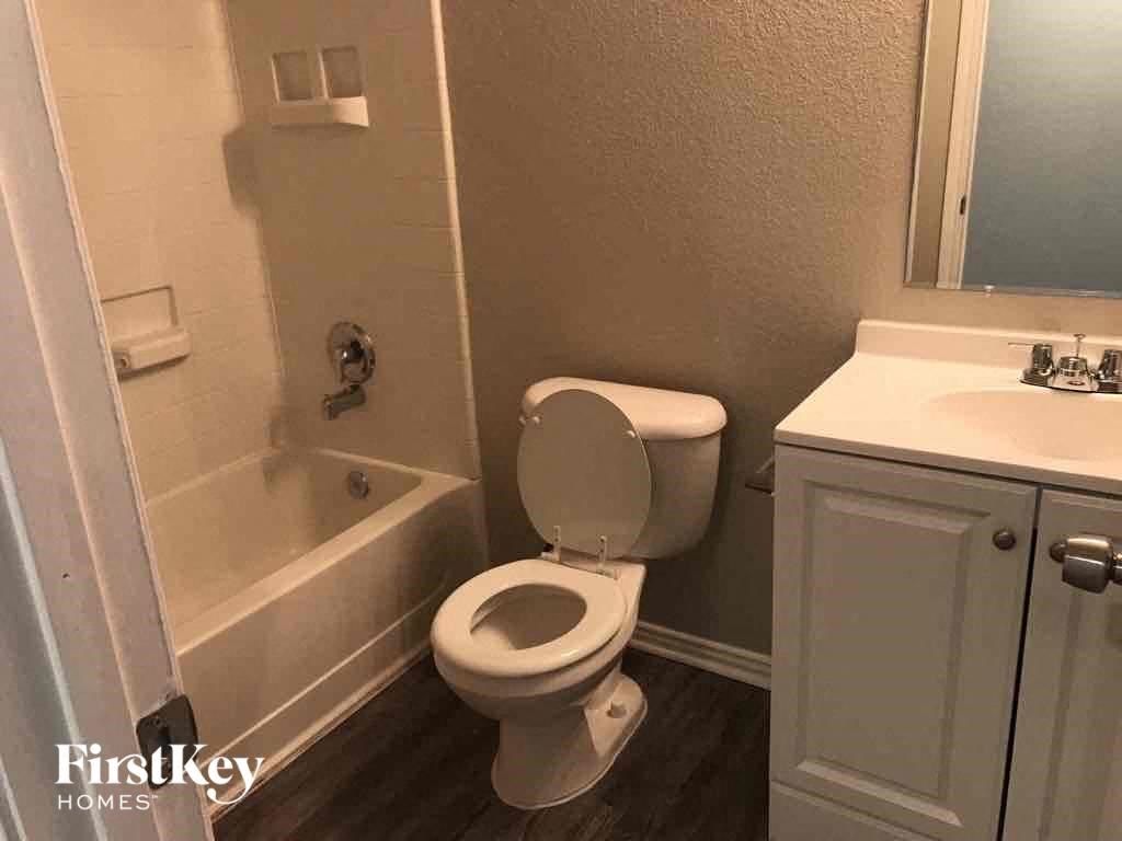 a bathroom with a toilet and a tub and a sink