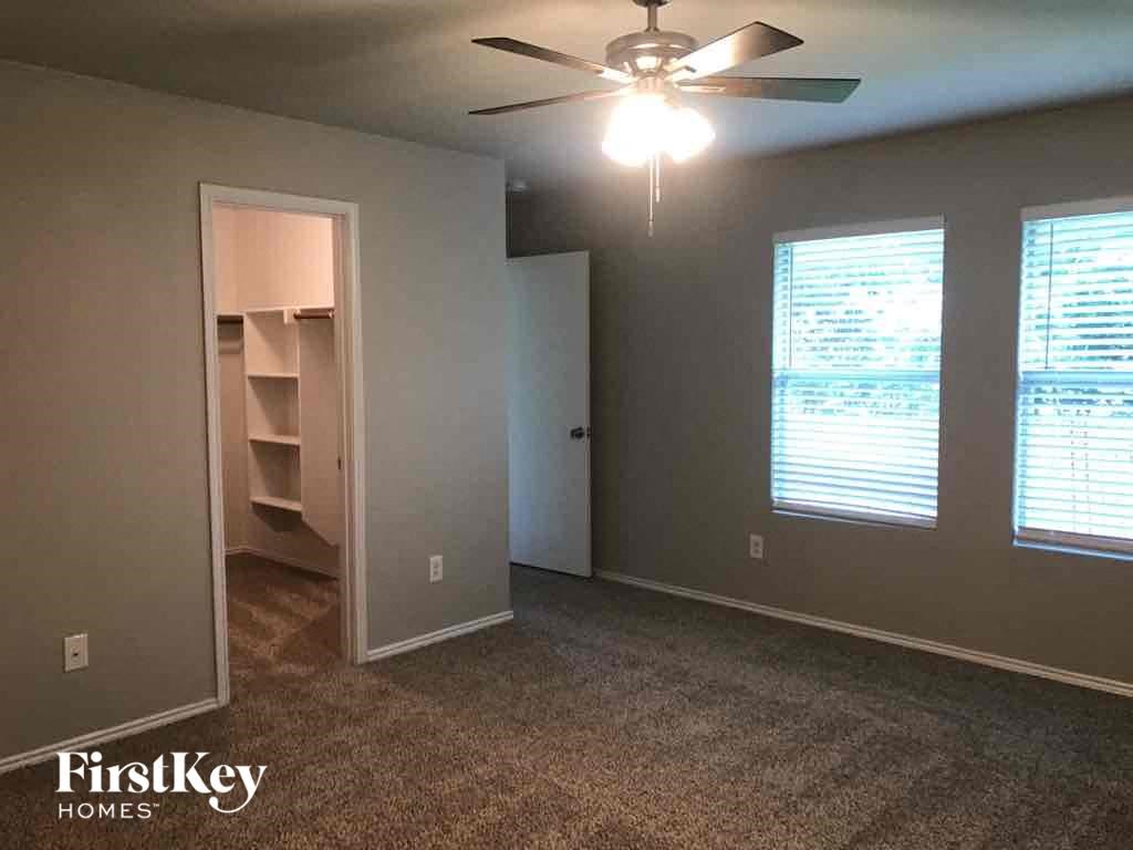 a bedroom with a closet and a ceiling fan
