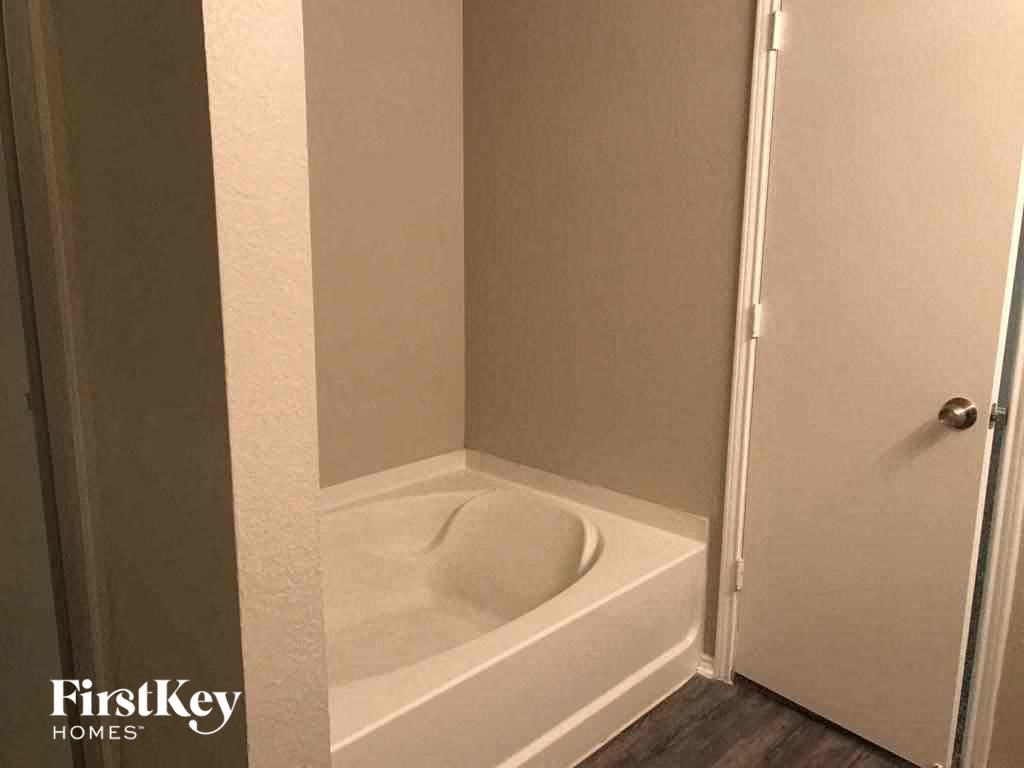 a small bathroom with a tub and a door