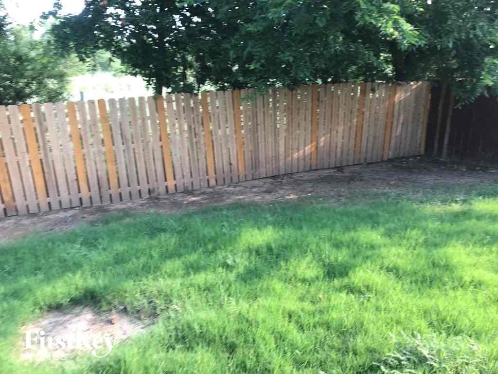 a wooden fence in a yard with green grass