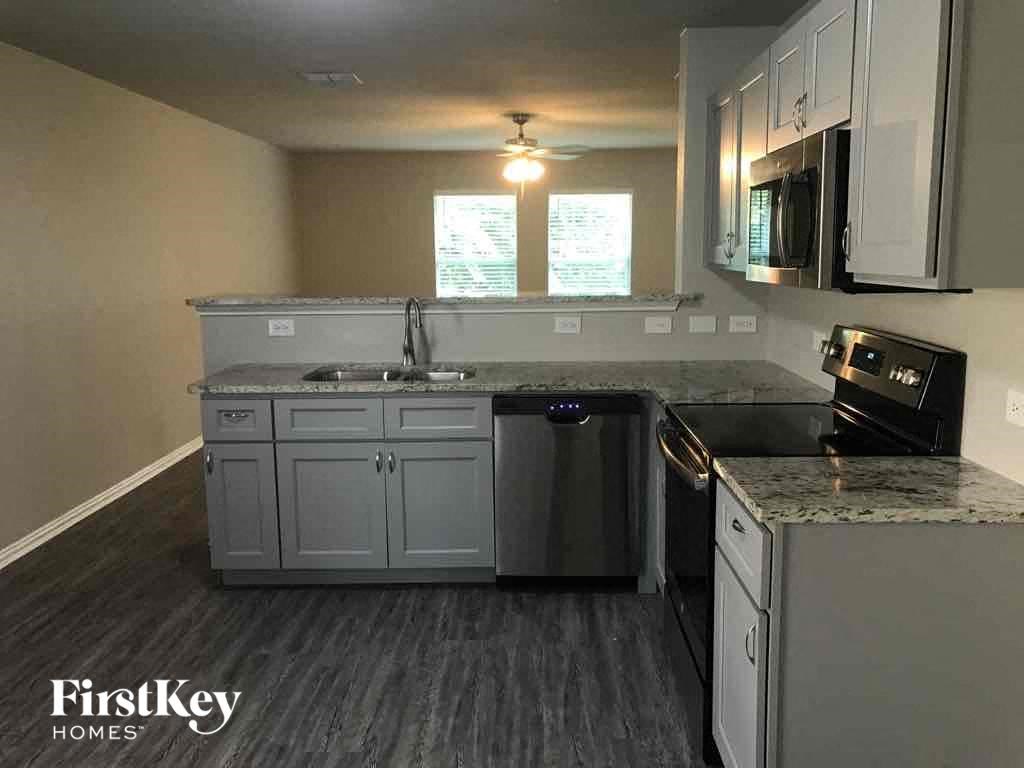 a kitchen with white cabinets and stainless steel appliances