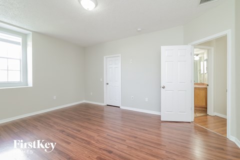 a living room with a hard wood floor and a white door