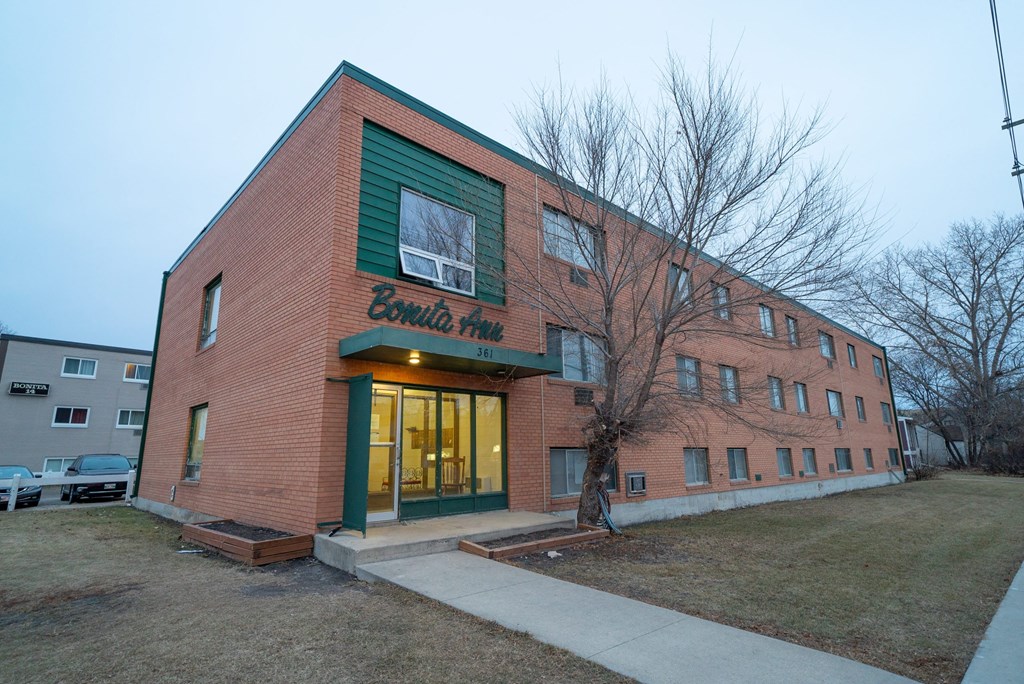 a brick building with a green roof and a sign on the front of it