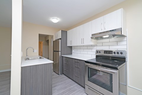 A kitchen with a stove top oven and a sink.
