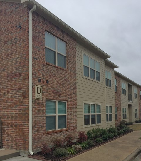 A brick building with a sign that says D on it.