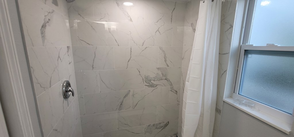 a bathroom with a shower and a window