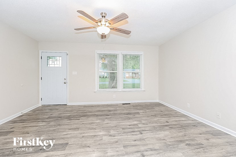 a living room with a ceiling fan and a door