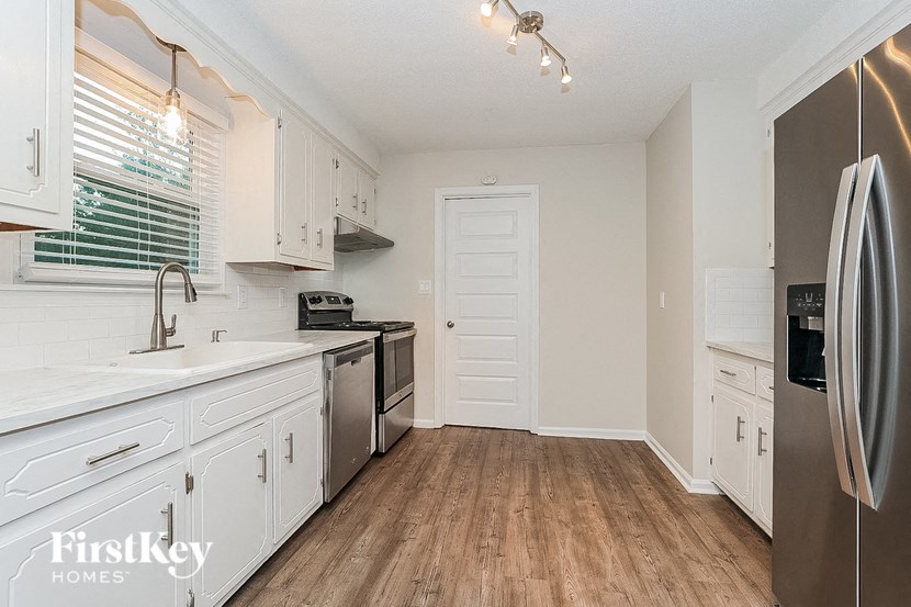 a renovated kitchen with white cabinets and stainless steel appliances