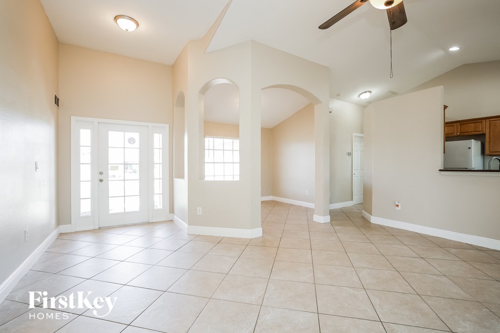 A spacious room with a fan and a mirror on the wall.