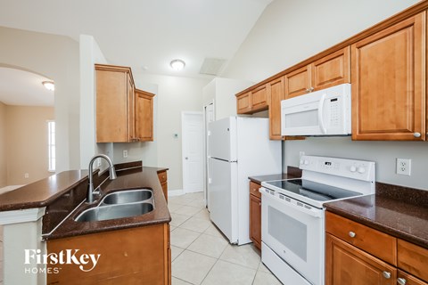 A kitchen with wooden cabinets and white appliances.