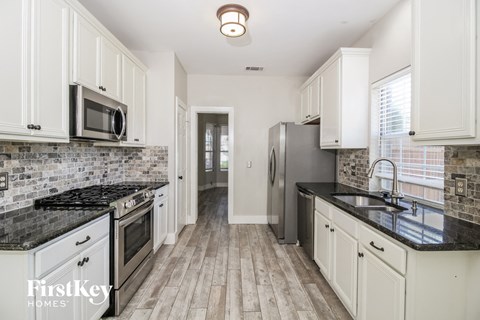a kitchen with white cabinets and stainless steel appliances