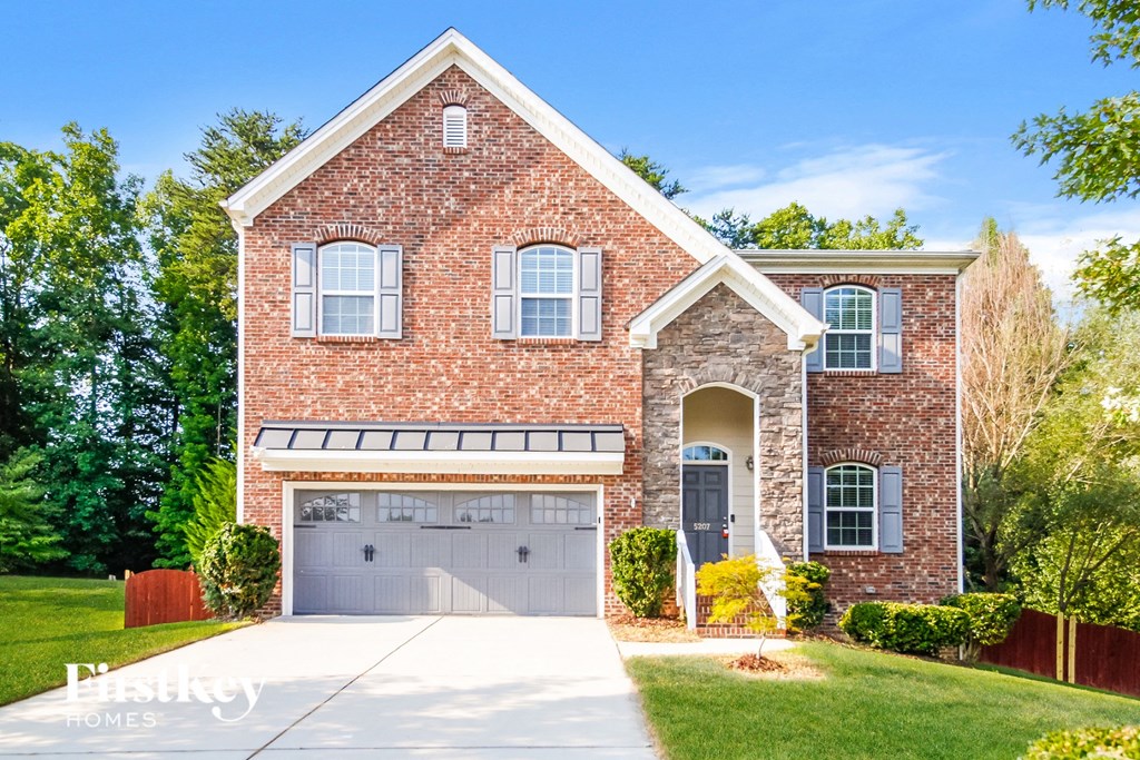 A brick house with a garage door and a driveway.