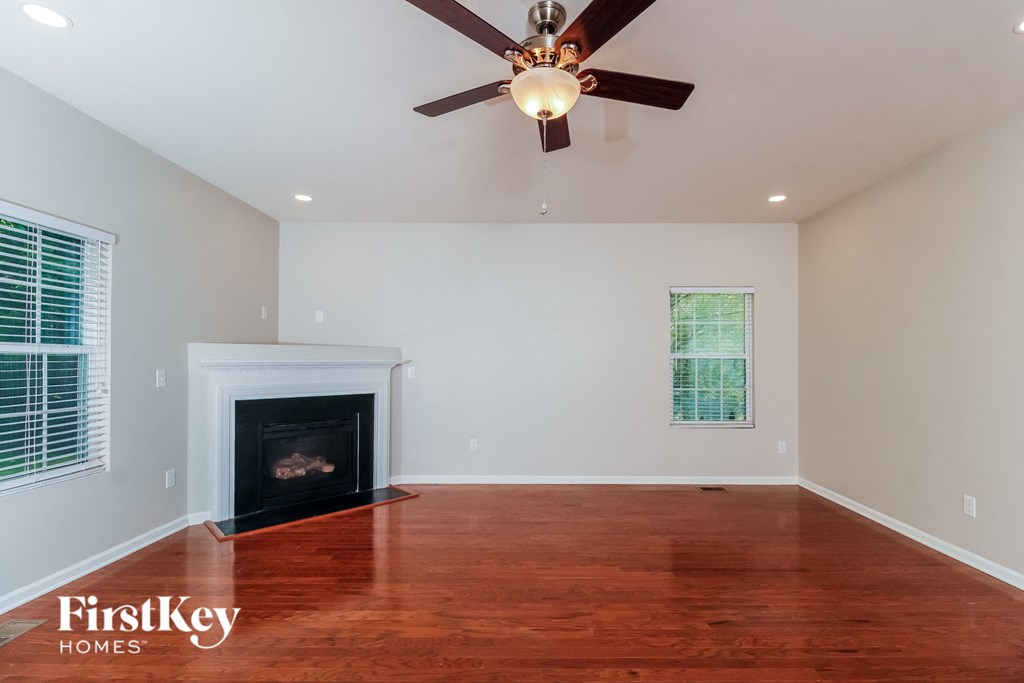 A spacious room with a fireplace and a ceiling fan.