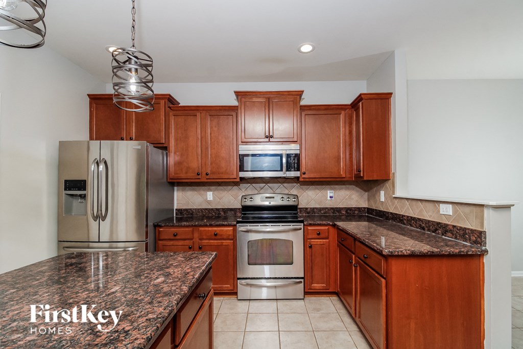 A kitchen with brown cabinets and a granite countertop.