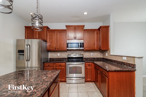 A kitchen with brown cabinets and a granite countertop.