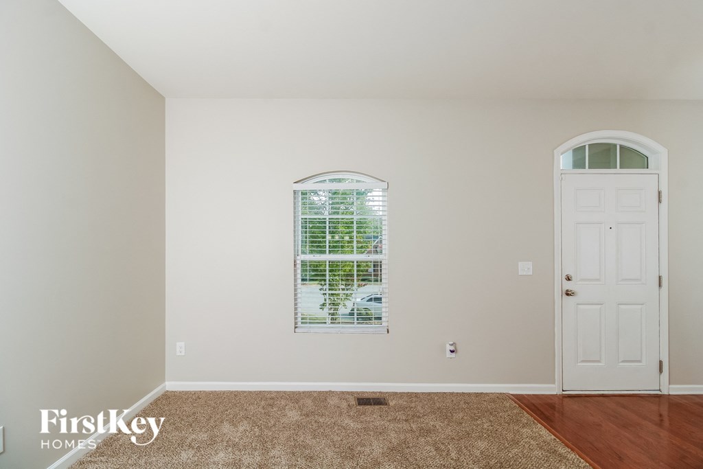 A room with a white door and a window with blinds.
