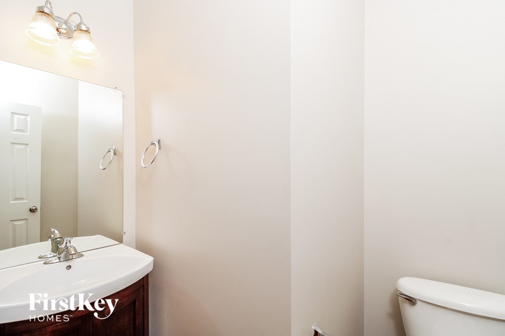 A white sink in a bathroom with a mirror above it.