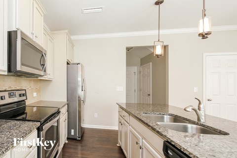 a kitchen with white cabinets and granite counter tops