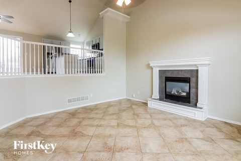 an empty living room with a fireplace and a staircase