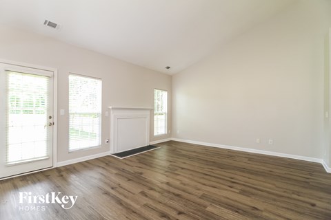 a living room with wood flooring and white walls and doors