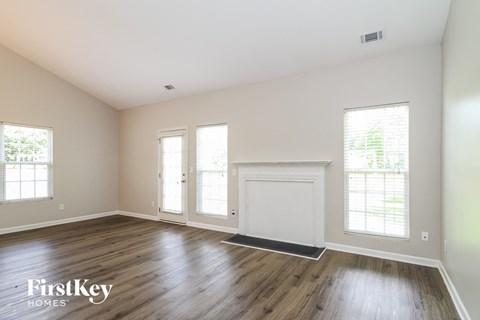 an empty living room with wood floors and white walls