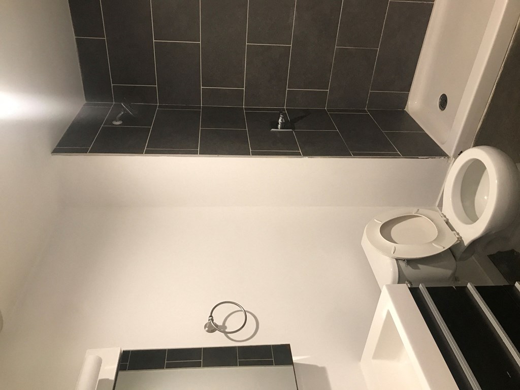 a small bathroom with a toilet and a black tiled floor