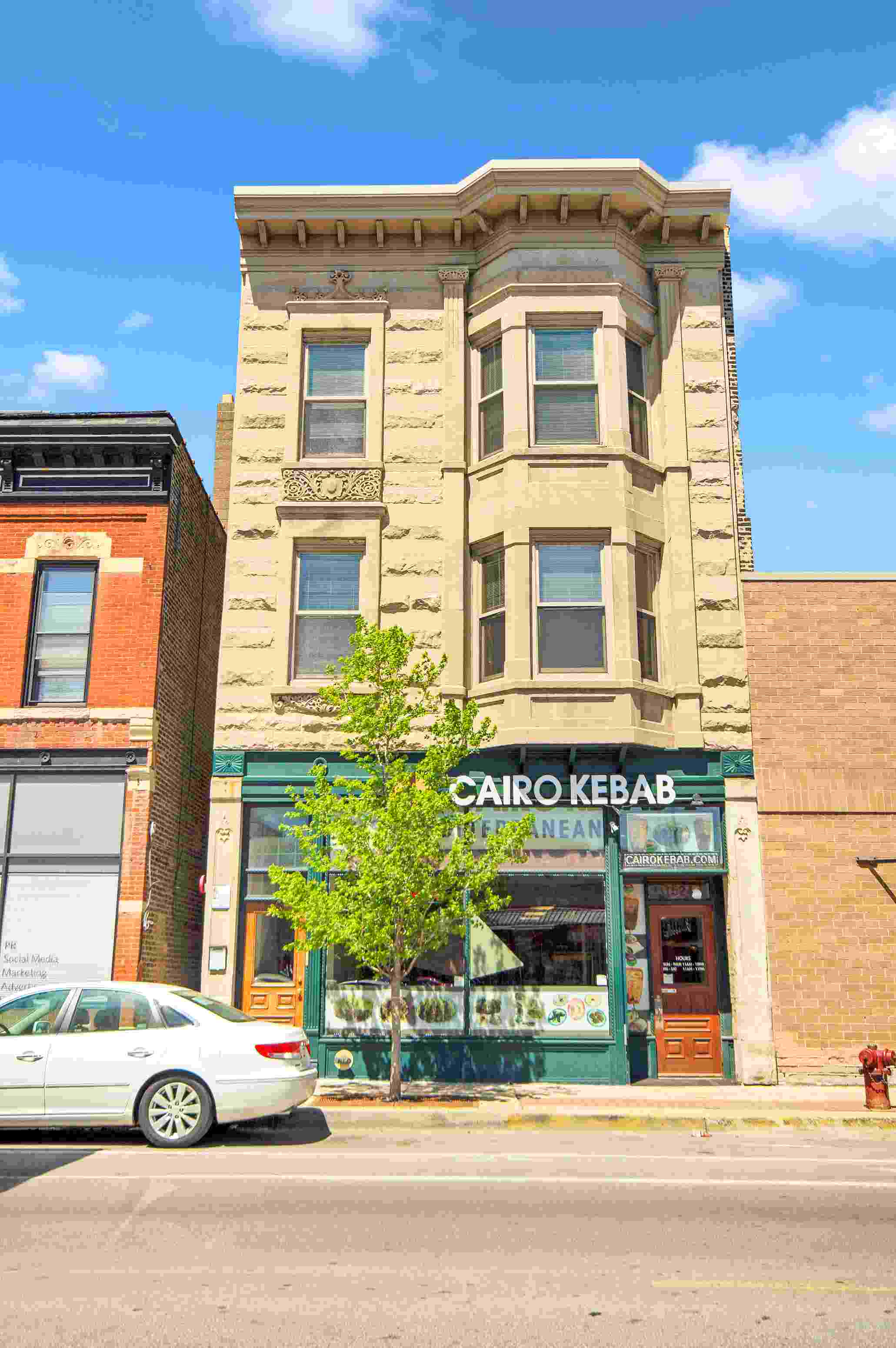 a white car parked in front of a building on a city street