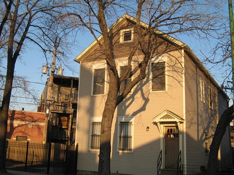 a yellow house with a tree in front of it