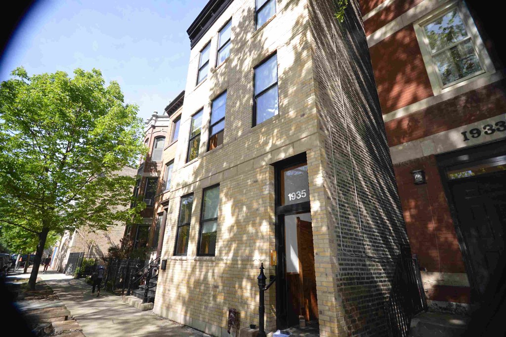 a building on a city street with a tree