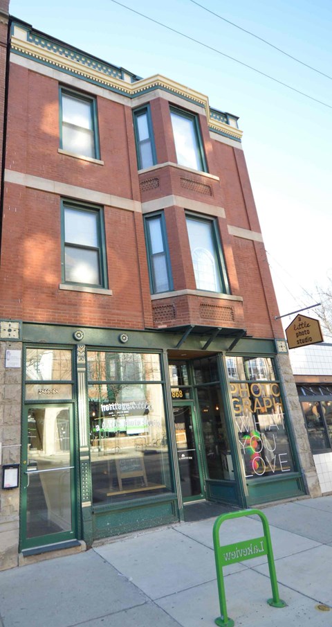 a building with a green sign in front of it