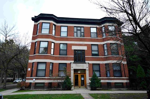 a large brick building with a sidewalk in front of it