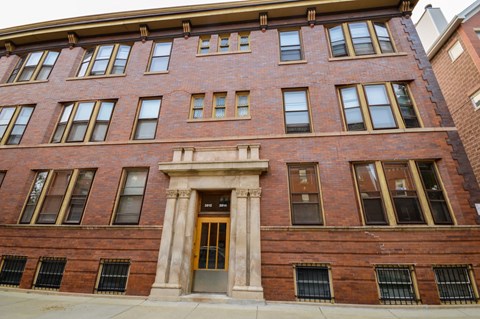 a red brick building with a golden door and columns