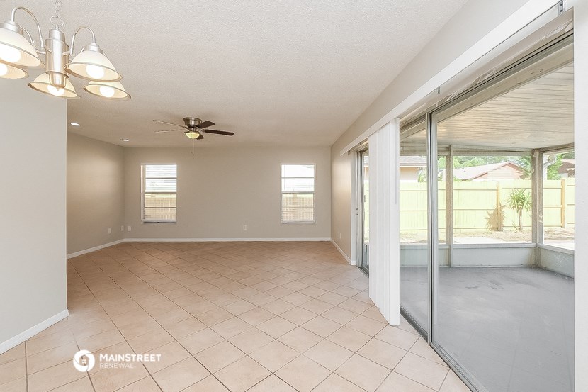 an empty living room with sliding glass doors to a patio